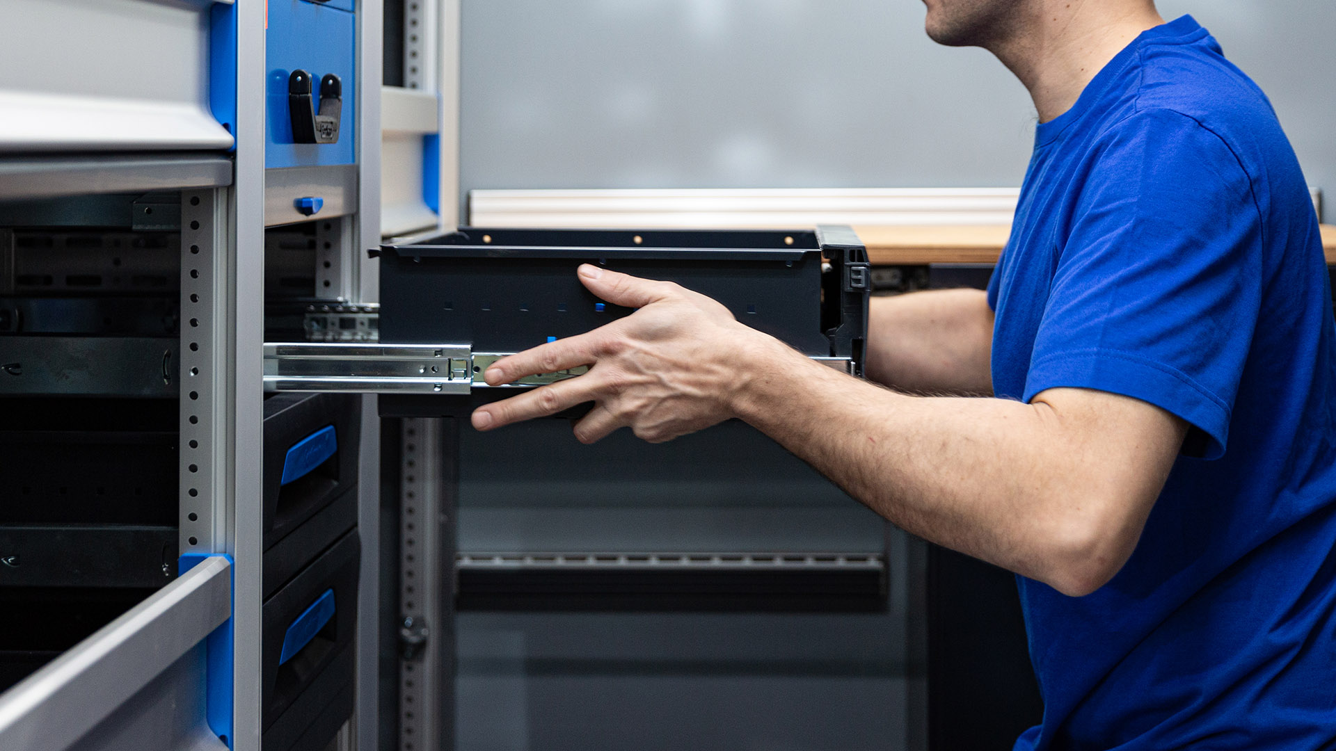 Mitarbeiter welcher ein Schubfach einbaut